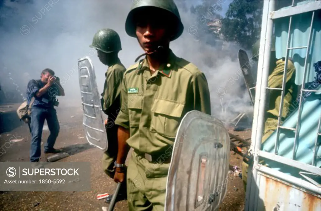Cambodia, Phnom Pehn, Anti Khmer Rouge Demonstration Outside Their City Headquarters.  Soldiers With Riot Shields And Press Photographer.