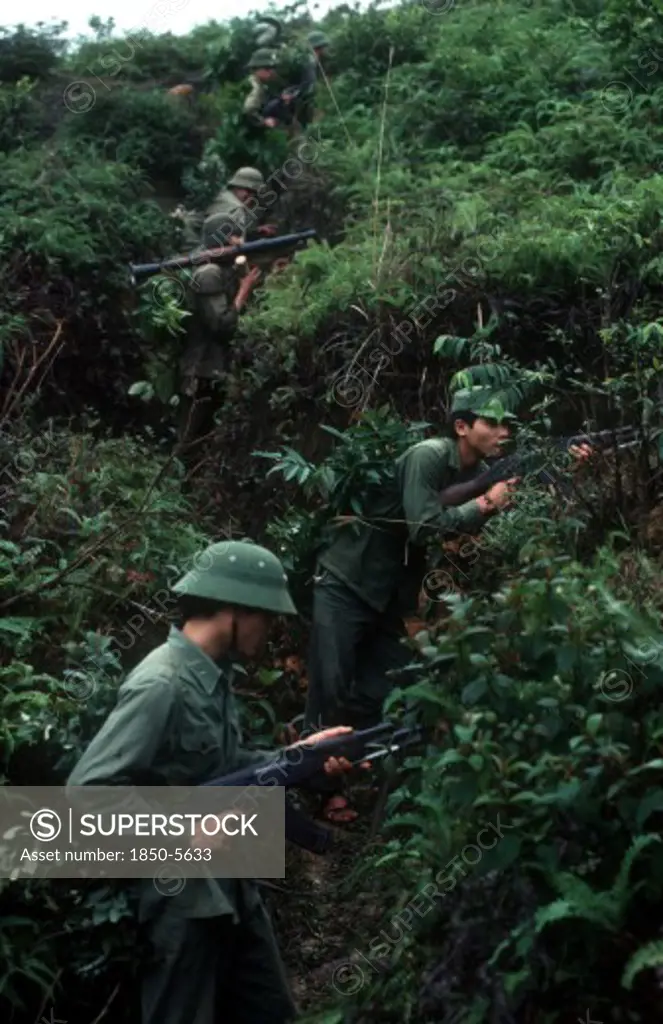 Vietnam, Cao Bang Province, Pac Bo, Soldiers On A Training Exercise.  View Up Hillside Along Advancing Line And Dense Undergrowth.
