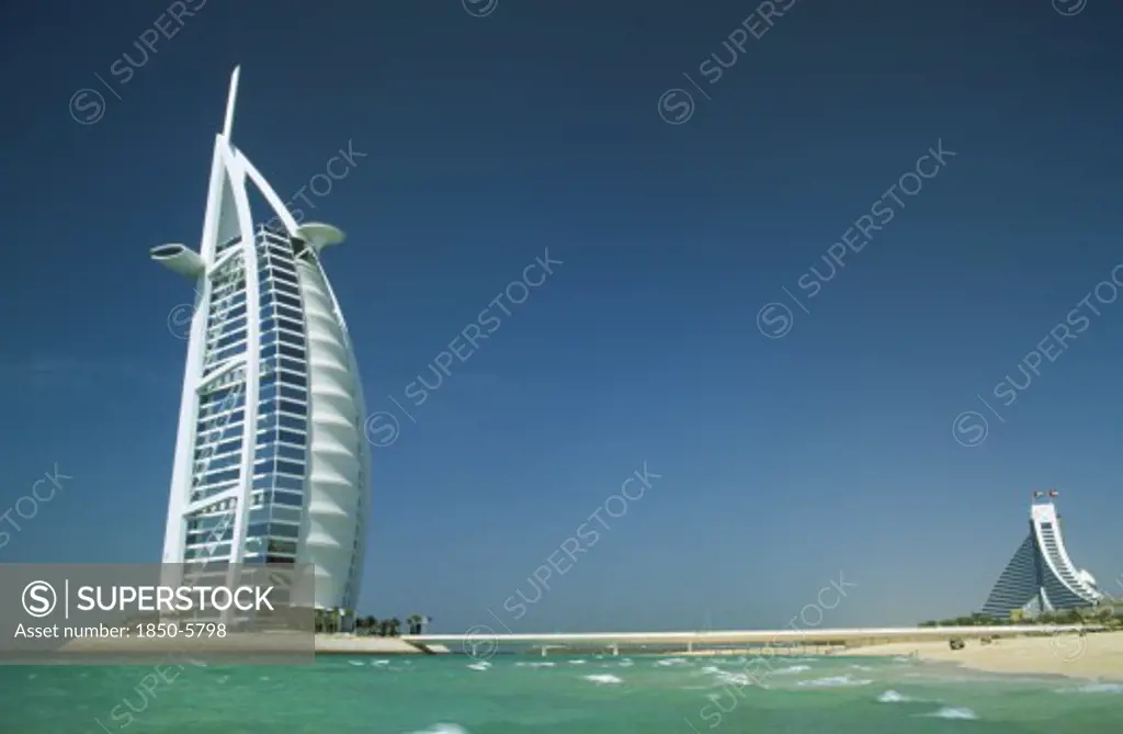 Uae, Dubai, The Burj-Al-Arab Hotel With The Jumeirah Beach Hotel In The Distance Behind.