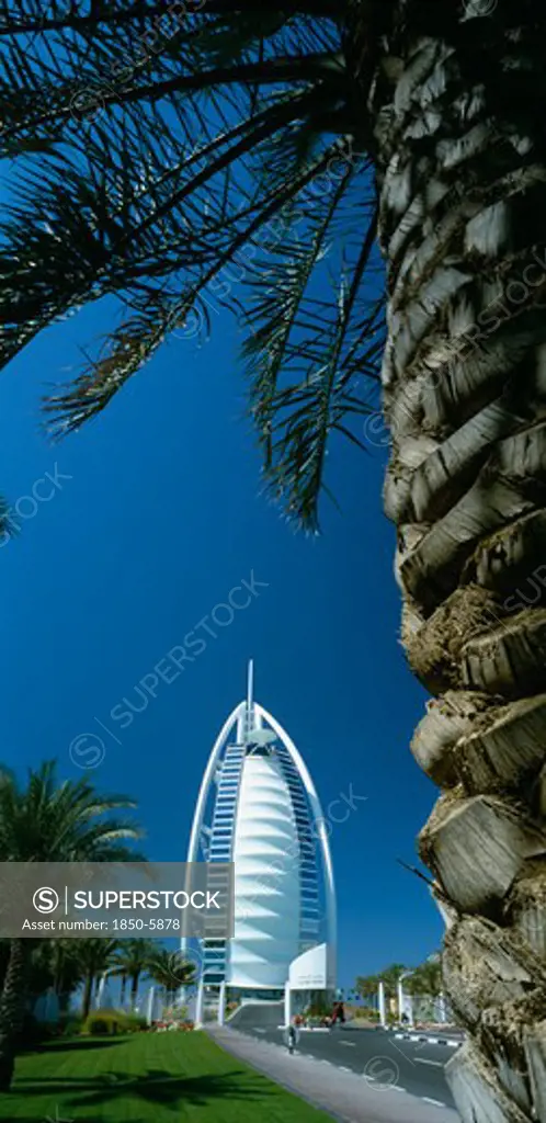 Uae, Dubai, The Jumeirah Beach Hotel With Palm Tree Trunk In The Foreground.
