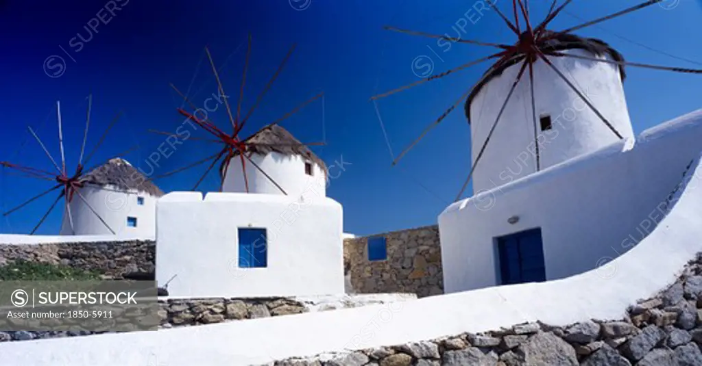 Greece, Cyclades Islands, Mykonos, Three White Painted Windmills Against Blue Sky.