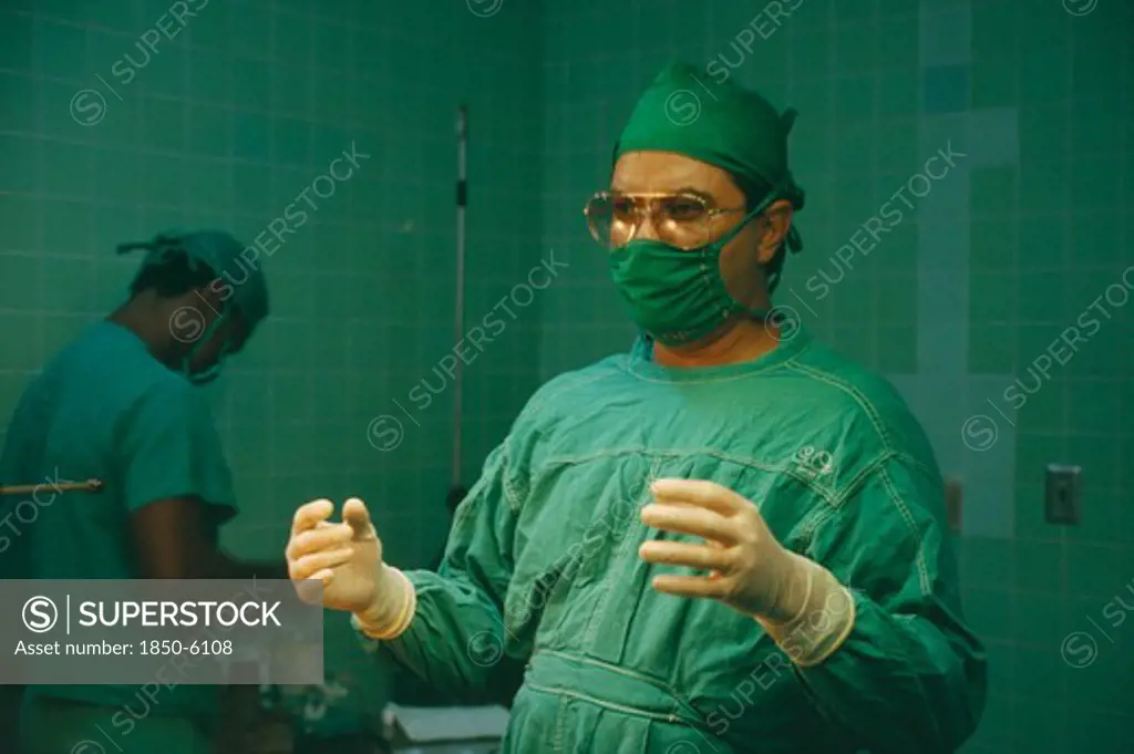Cuba, Havana, Doctor In Theatre Greens And Sterile Gloves Ready To Perform Operation