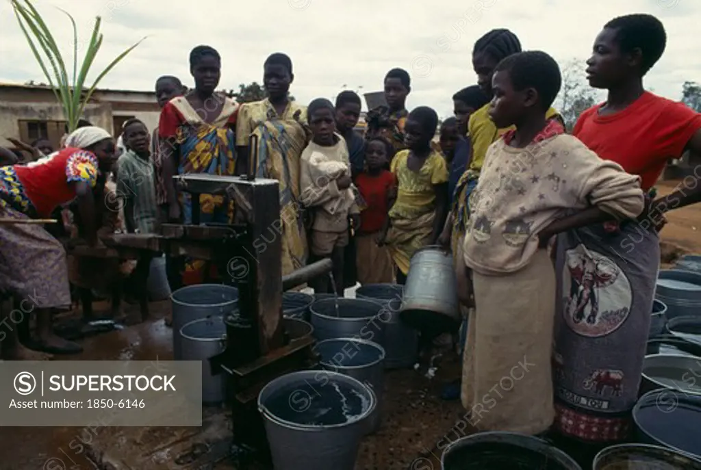 Malawi, People, Women And Children Crowded Around Water Pump With Buckets.