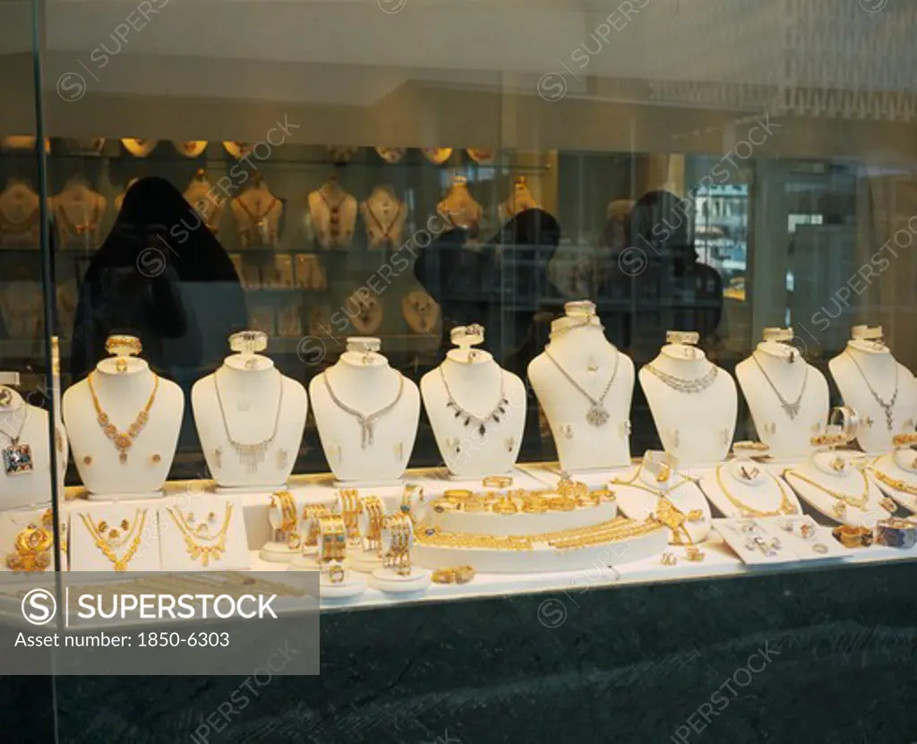 Kuwait, Kuwait City , 'Gold Souq.  Three Women In Black Burqa Inside Jewellery Shop, Seen Through Window With Display  Of Gold And Silver.'