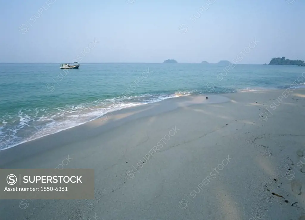 Thailand, Trat Province, Koh Chang, 'Lonley Beach, Aow Bai Lan. Fishing Boat Seen At Anchor Off The Shaded Beach With Small Islands In The Distance.'