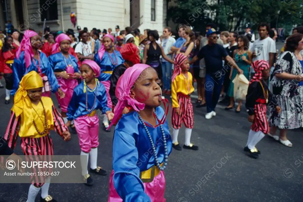 England, London, Notting Hill Carnival. Children In Costume Blowing Whistles During Parade.