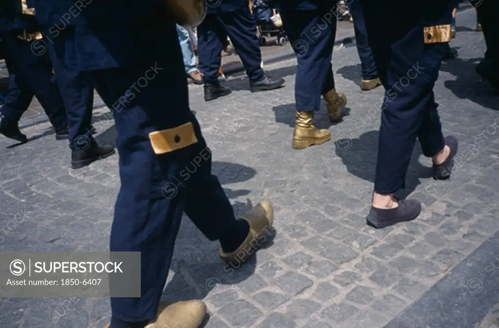 Belgium, West Flanders, Bruges, Parade Of People Wearing Golden Clogs In Steenstraat During Braderie Festival