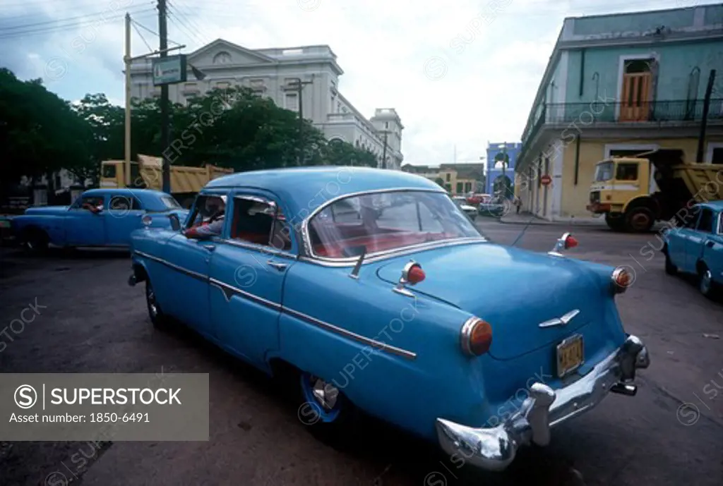 Cuba, Matanzas, Old Blue American Cars Being Driven In The Street