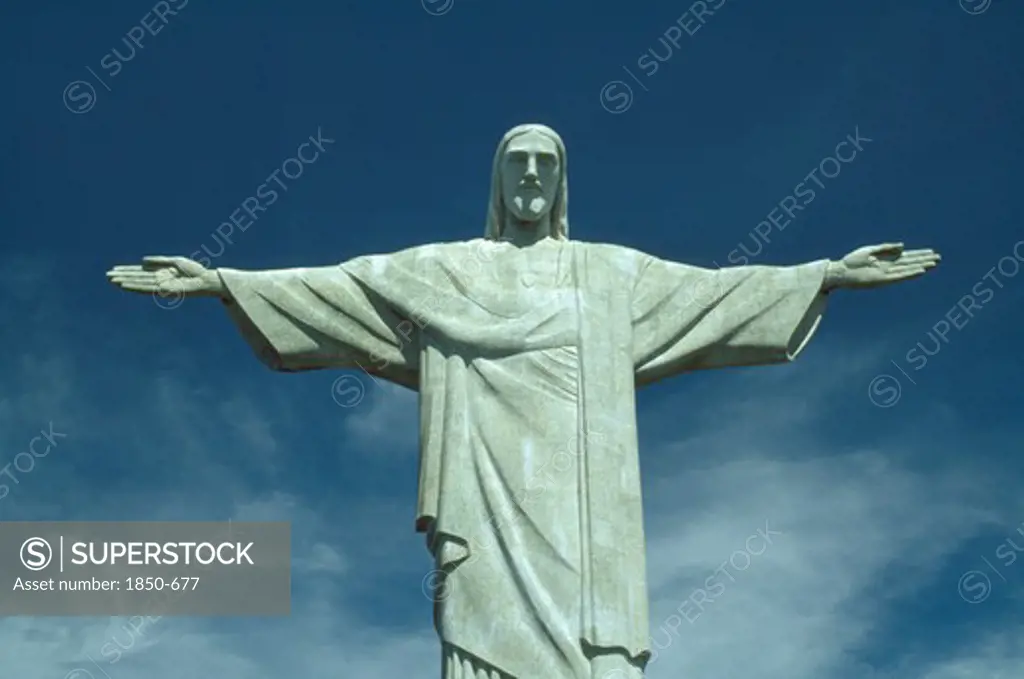Brazil, Rio De Janeiro, Cocovado Statue Of Christ The Redeemer With Outstretched Arms Against Backdrop Of Blue Sky