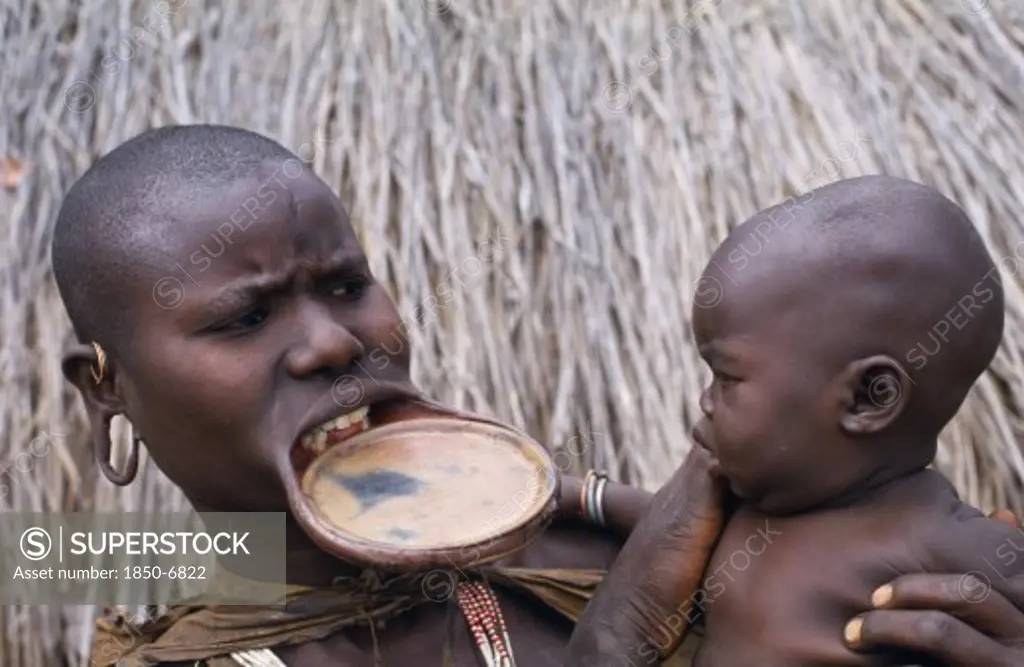 Ethiopia, Western Highlands, Children, Surma Woman With Lip Plate Holding Baby.