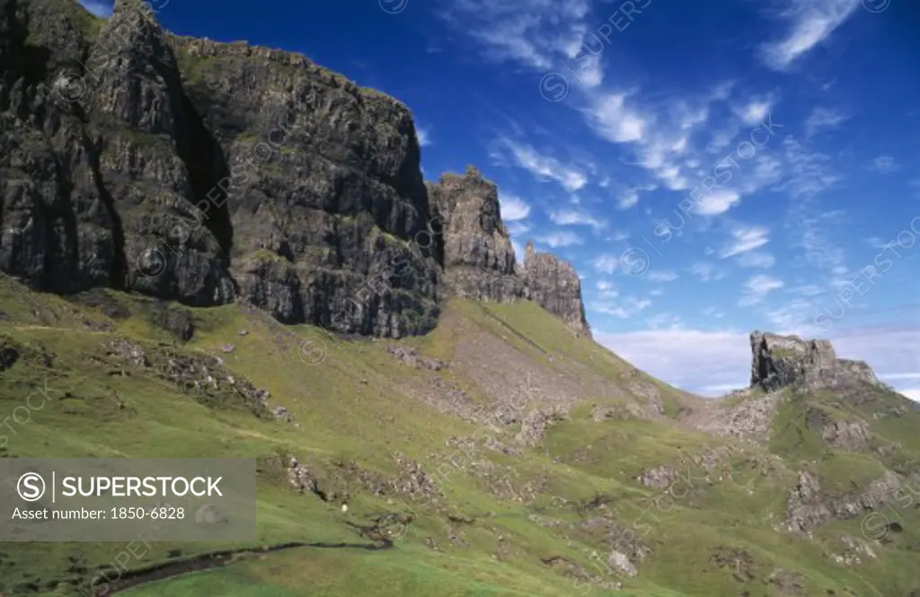 Scotland, Isle Of Skye, North, Quiraing Escarpment Mountains With Walker On Lower Slopes.