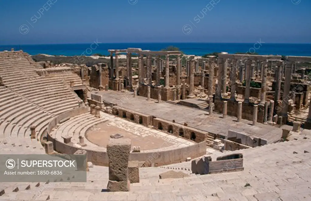 Libya, Tripolitania, Leptis Magna, View Over Roman Amphitheatre Towards The Mediterranean Sea Behind.