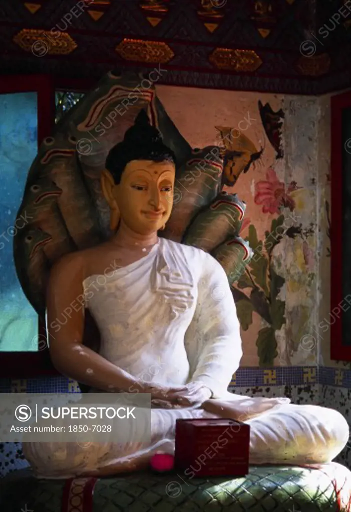Malaysia, Penang, Georgetown, 'Wat Chayamangkalaram.  Interior With Seated Buddha Figure In Meditative Pose On Coiled Naga With Painted, Multi Headed Hood.'