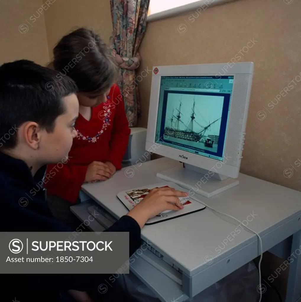 Industry, Computers, Children, Young Boy And Girl Sitting At A Home Computer Looking At Educational Web Site With Image Of Hms Victory On The Screen.