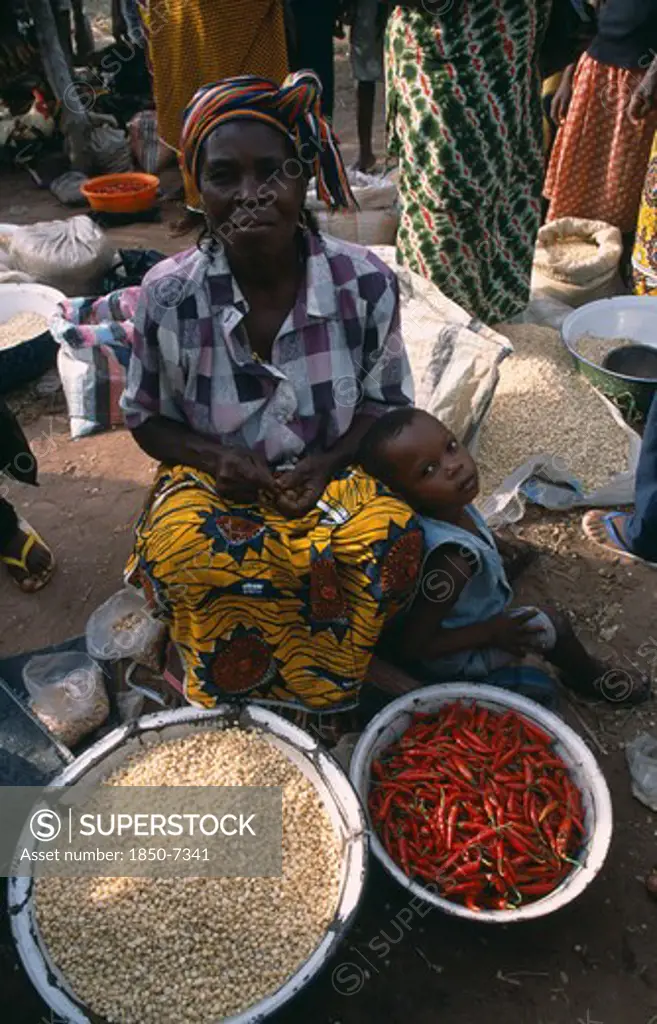 Nigeria, Enugu, Woman Selling Chillies And Pulses At A Market Stall
