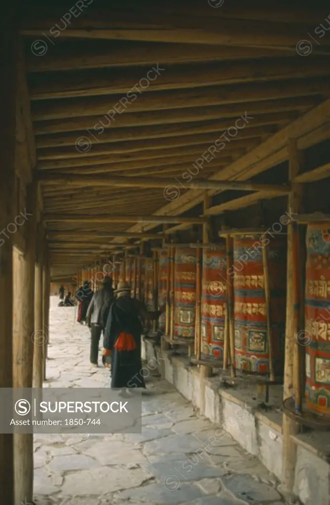 China, Gansu Province, Labrang Monastery, Tibetan Pilgrims Turning Prayer Wheels.
