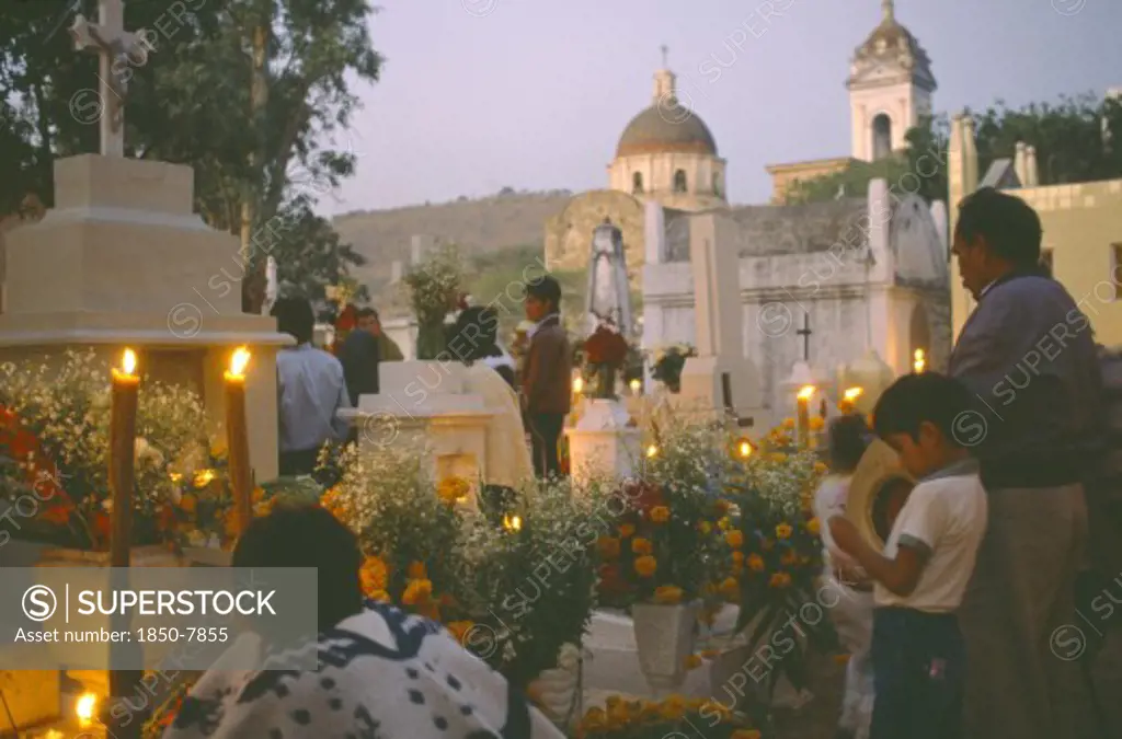 Mexico, Puebla, Acatlan, People Keeping Vigil Beside Graves Decorated With Candles And Flowers During Night Of The Dead
