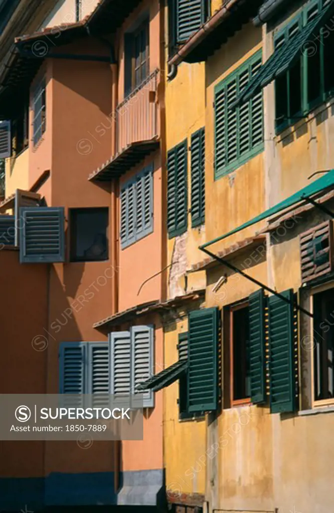 Italy, Tuscany, Florence, Ponte Vecchio. Facades Of Colourful Buildings With Detail Of Wooden Shutters Seen In Golden Light