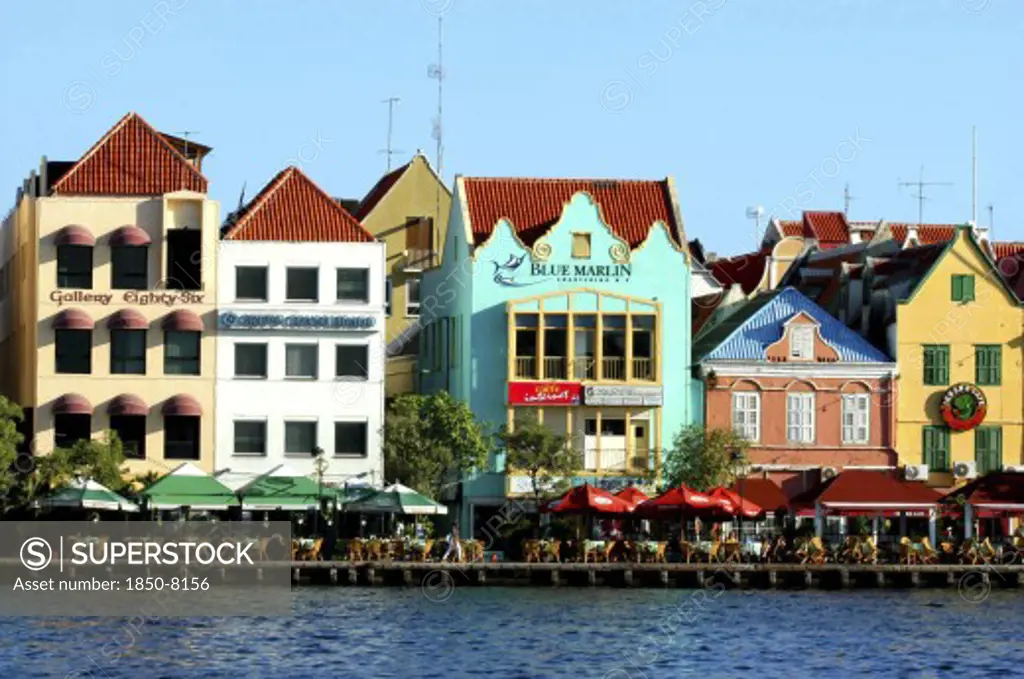 West Indies, Dutch Antilles, Curacao, Old Willemstad. Row Of Brightly Painted Waterfront Restaurants And Cafes