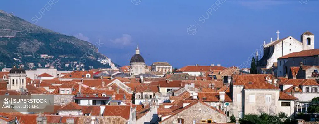 Croatia, Dalmatia, Dubrovnik, View Through A Slit In The City Walls Over The Rooftops Looking Toward The Cathedral Dome