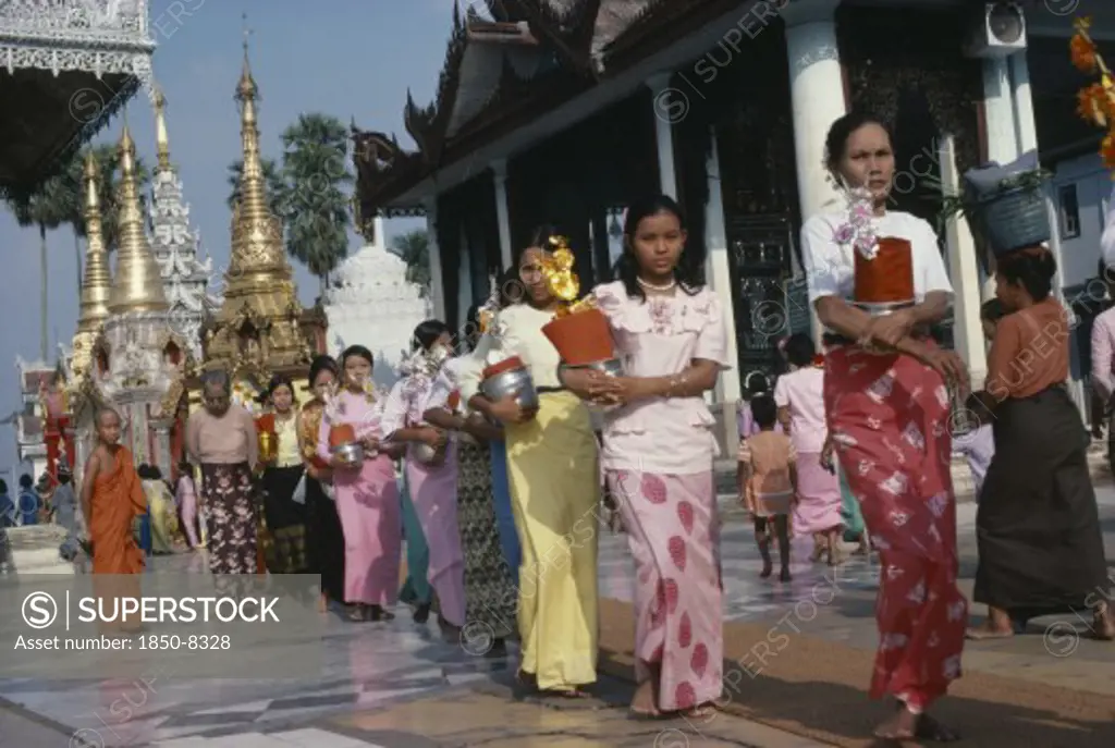 Myanmar, Yangon, Shwedagon Pagoda.  Line Of Young Women With Offerings.