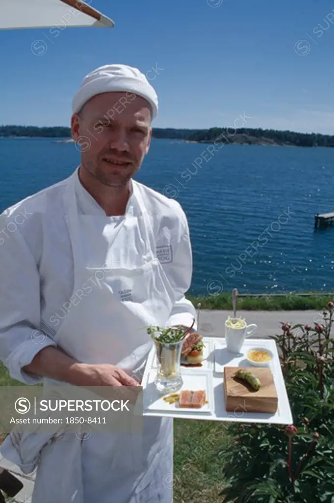Sweden, Oaxen Island, Magnus Ech Owner And Chef Holding A Tray Of Food At Oaxen Skargards Krog Restaurant