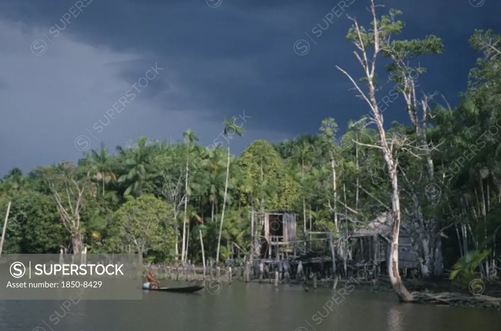 Brazil, Amazonas, Amazon Basin, View Toward Riverside Cabloclo Settlement With Dark Storm Clouds Overhead