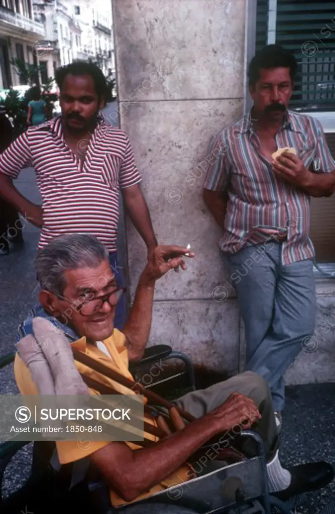 Cuba, Havana, 'Three Men On A Street Corner, One In A Wheelchair Smoking'