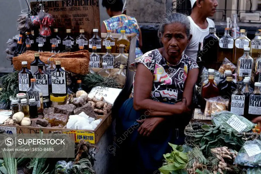 Philippines, Luzon, Manila, Woman Selling Various Medicines On Market Stall.