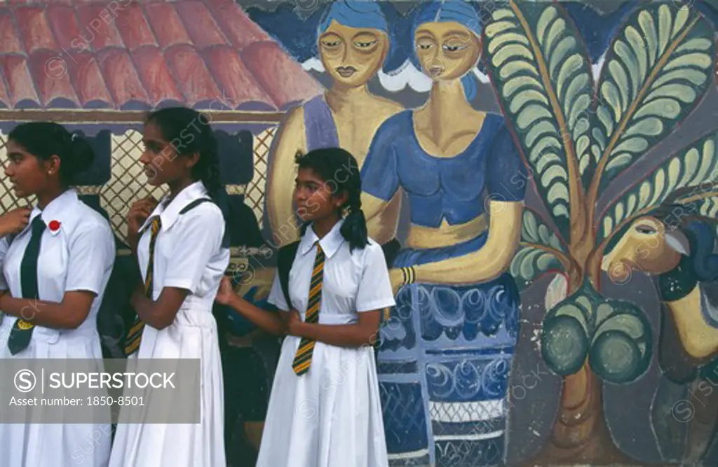 Sri Lanka, Colombo, Group Of School Girls Dressed In White Standing Next To Mural