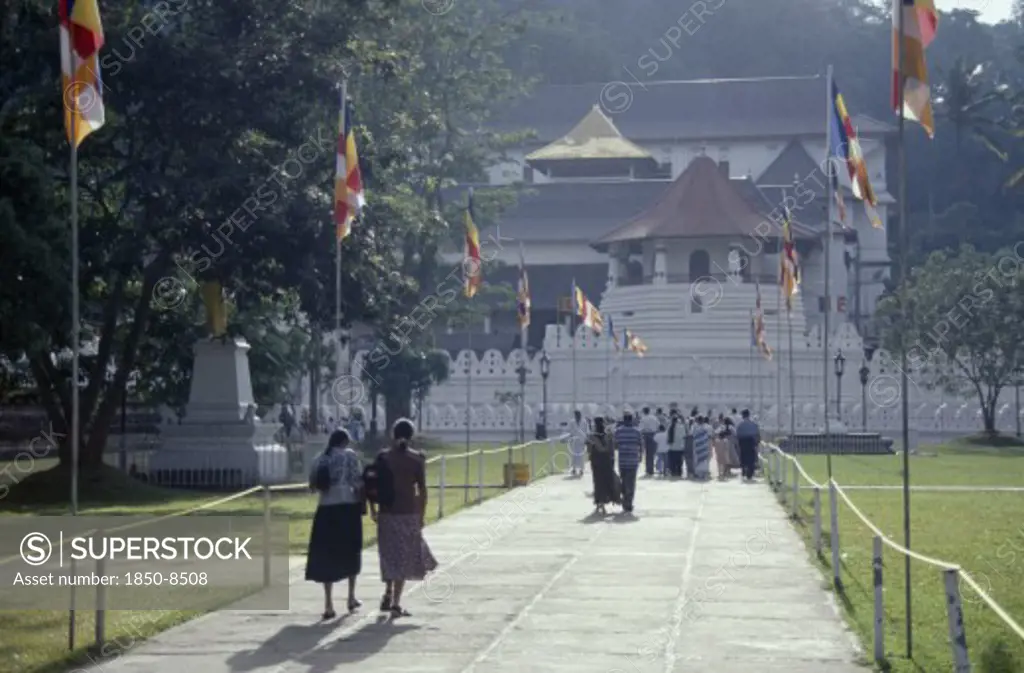 Sri Lanka, Kandy, People Walking Down Flag Lined Walkway Toward The Temple Of The Tooth