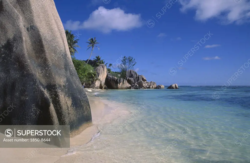 Seychelles, La Digue Island, Anse Source DArgent. View From Behind Large Rock Boulders On Golden Sandy Beach Looking Along Coastline