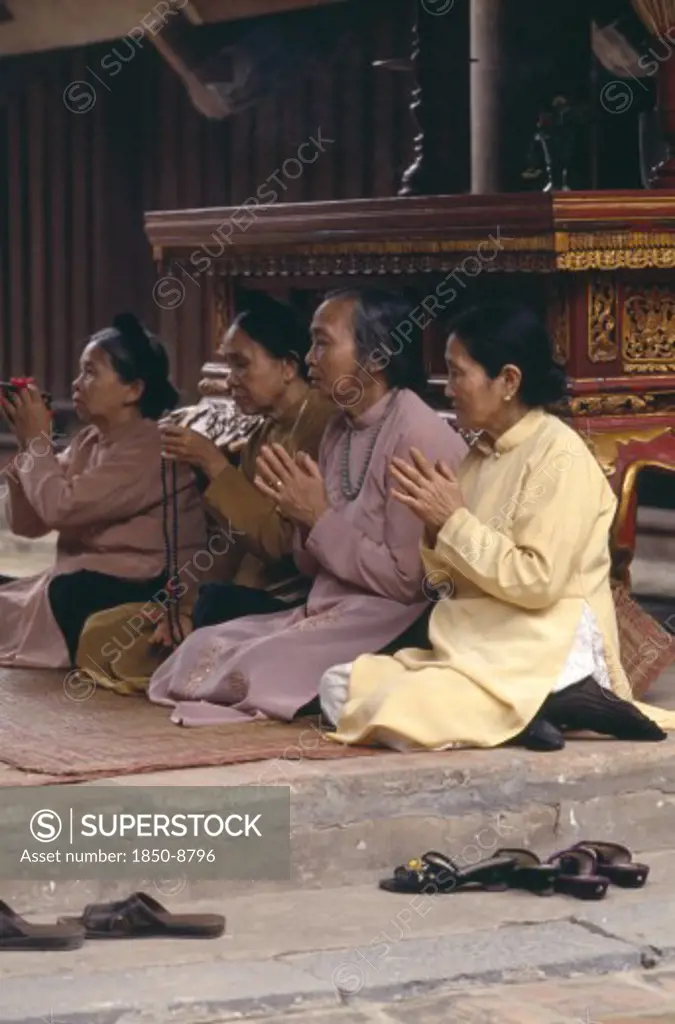 Vietnam, North, Hanoi, Buddhist People Sitting In Prayer