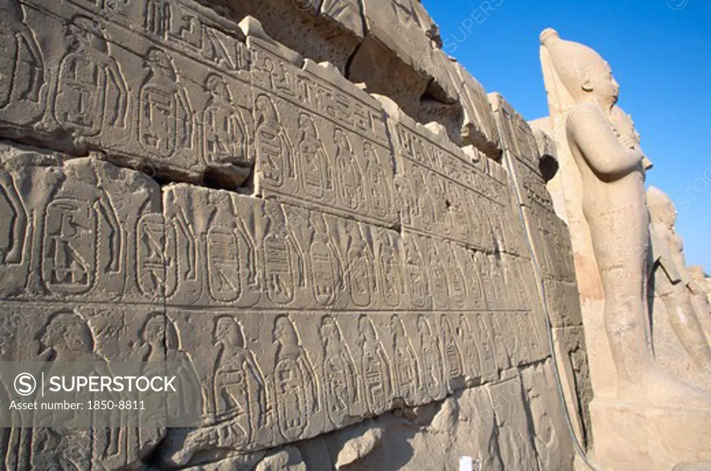 Egypt, Nile Valley, Karnak, Precinct Of Amun.  Detail Of Relief Carving And Hieroglyphics Along Wall Of Building Leading To Colossi.