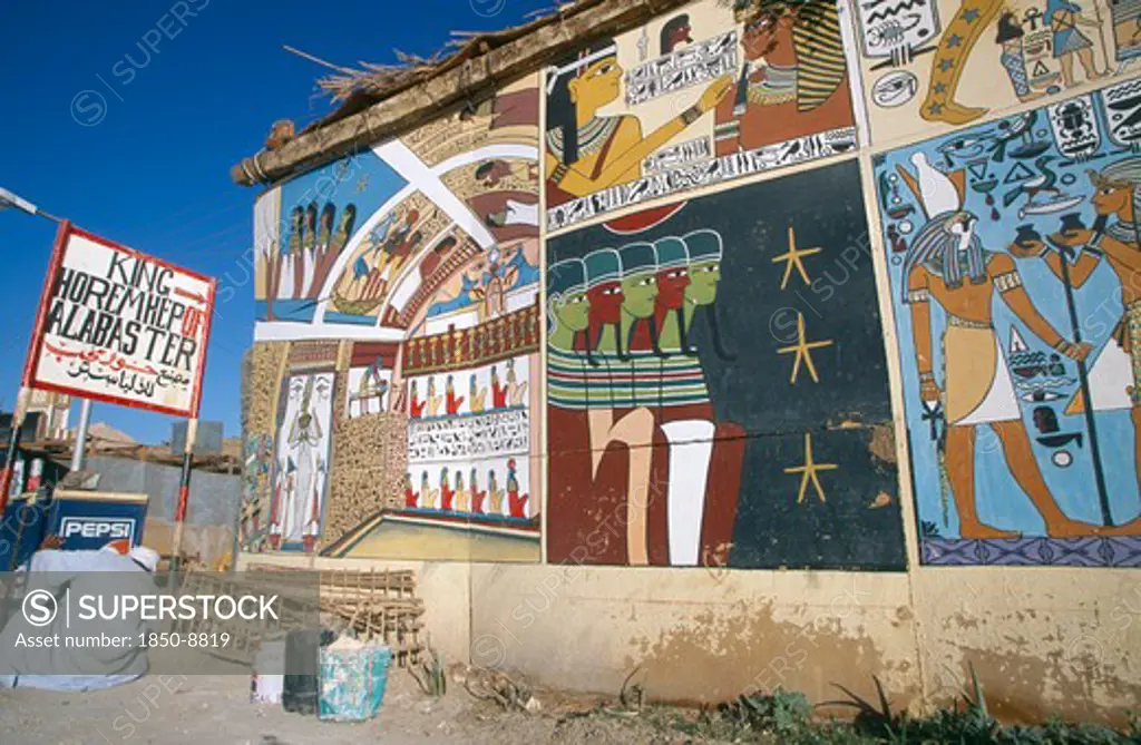 Egypt, Dra Abul Naga, Painted Mural On Exterior Wall Of Alabaster Shop With Man Crouched Down Beside Pepsi Sign Outside.