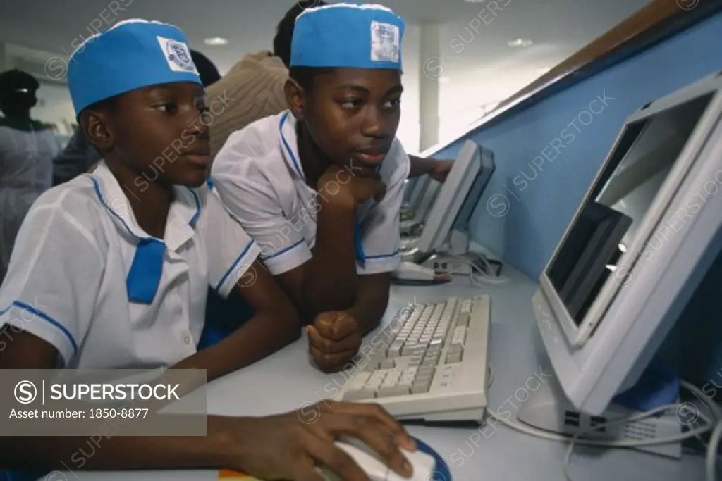 Nigeria, Abuja, Two Children In Uniform Working On A Computer At The British Council