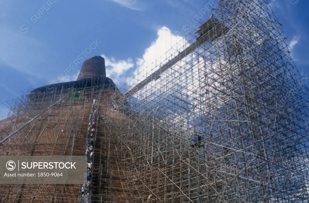Sri Lanka, Anuradhapura, Jetavanarama Dagoba.  Huge Brick Dome Undergoing Reconstruction.  Line Of Workers On Network Of Scaffolding Covering Exterior.