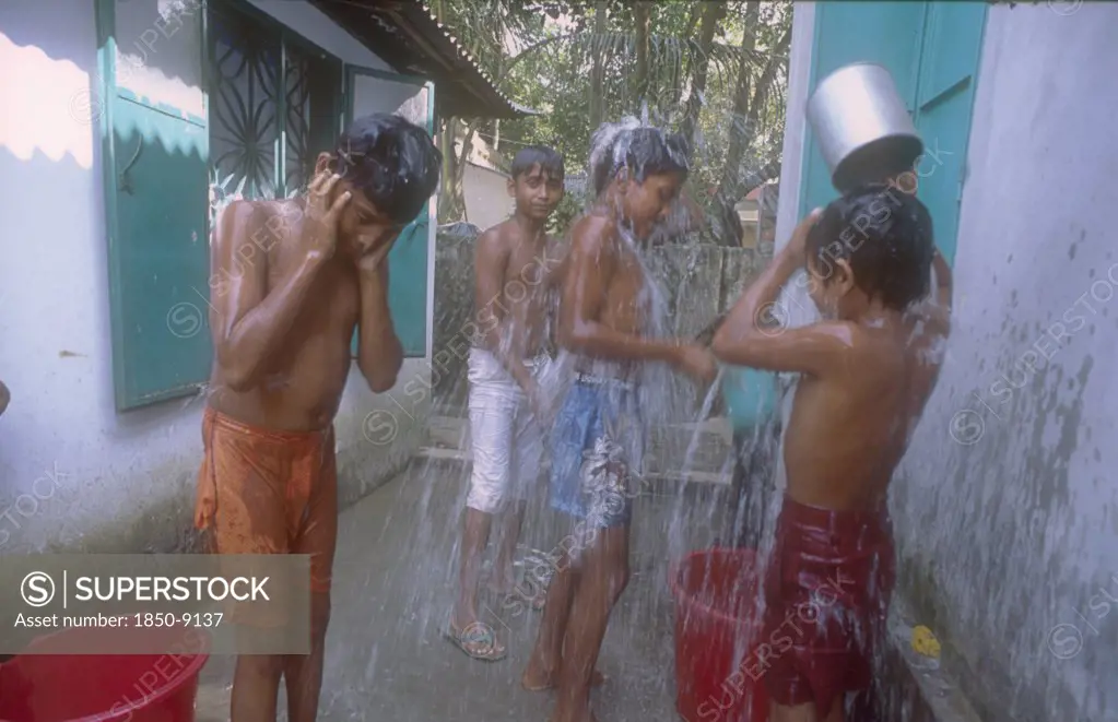 Bangladesh, Savar, Dhaka, Street Boys In A Refuge Home Bathing Using Buckets And Cups.
