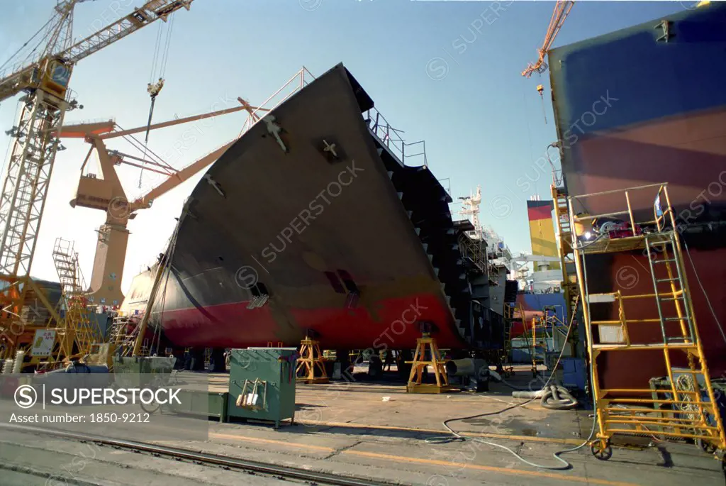 South Korea, Pusan, Dae-Woos New Ship Building Yard With Section Of Ship Surrounded By Cranes