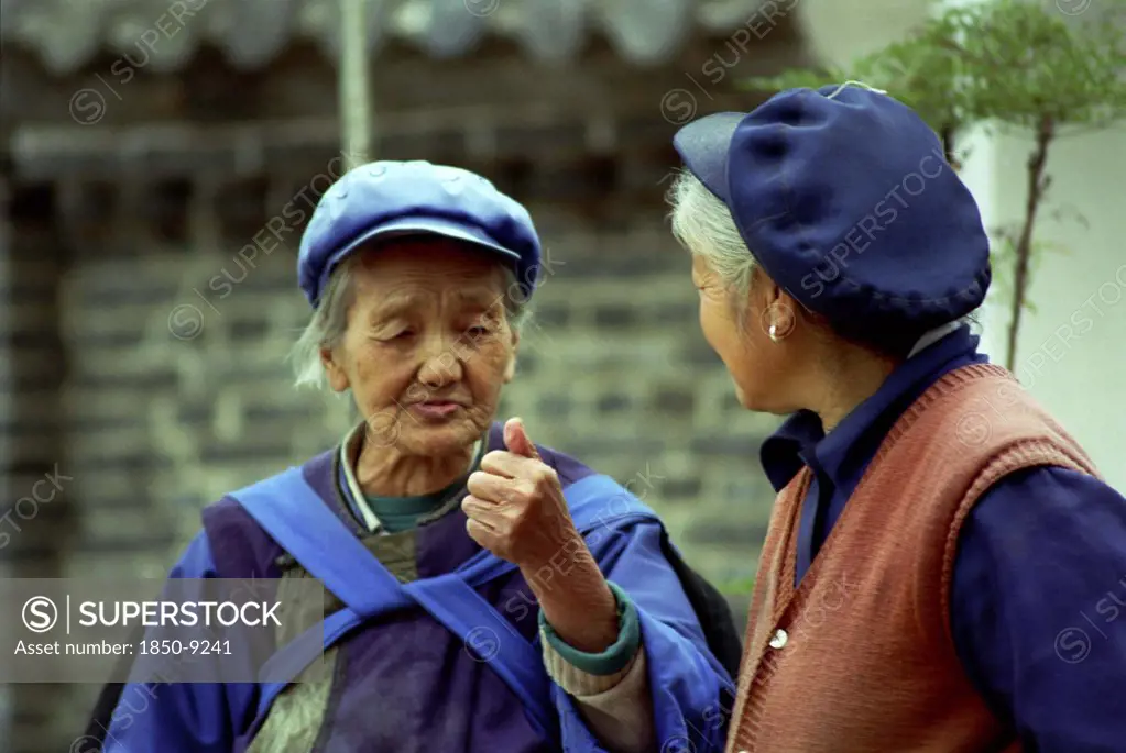 China, Yunnan, Lijiang, Two Elderly Women Talking In The Street