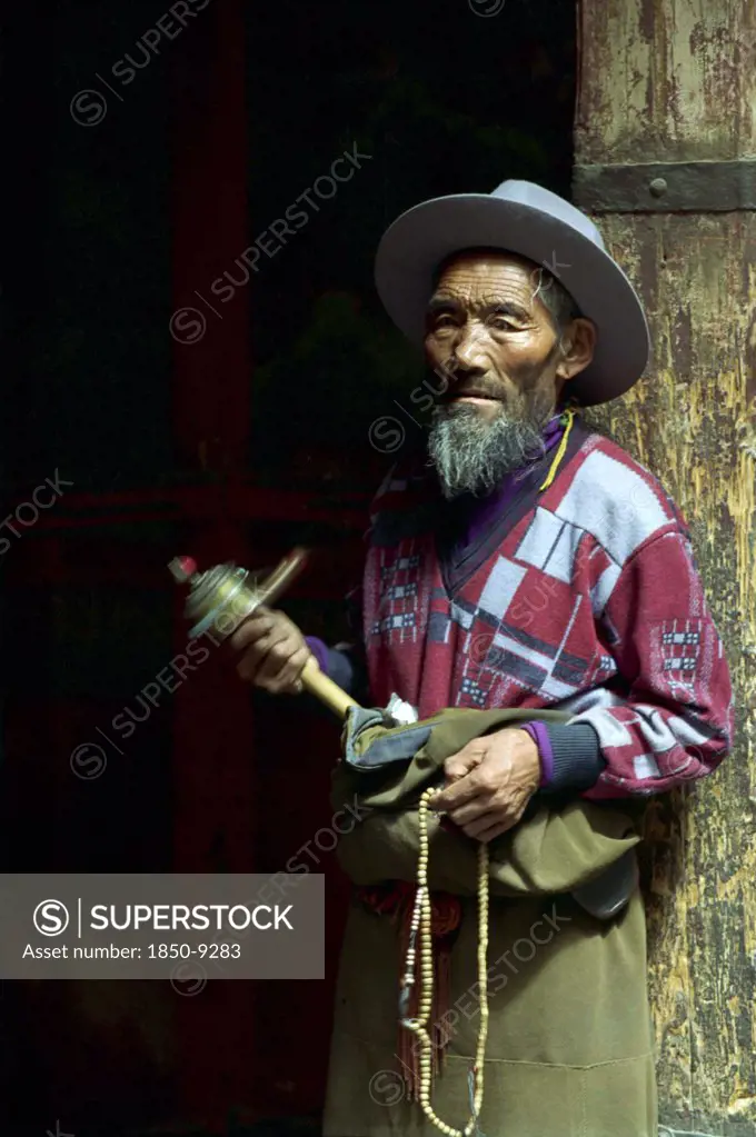 China, Tibet, Lhasa, Portrait Of A Man Spinning A Mini Prayer Wheel At The Jokhang Temple