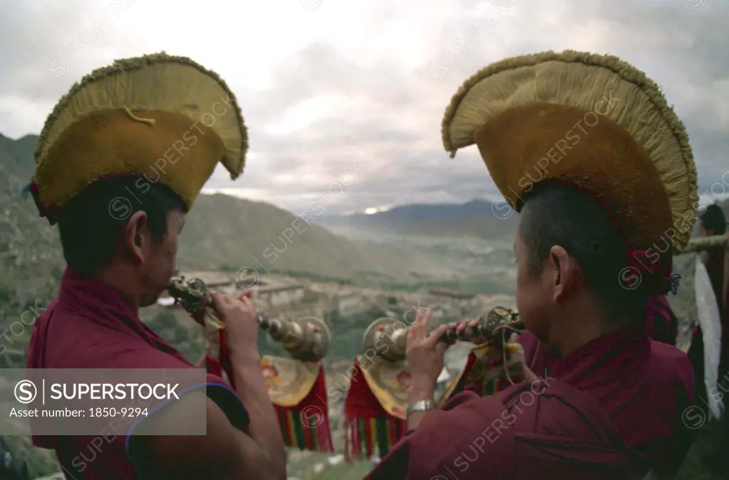 China, Tibet, Drepung Monastery, Two Monks Blowing Spiritual Horns