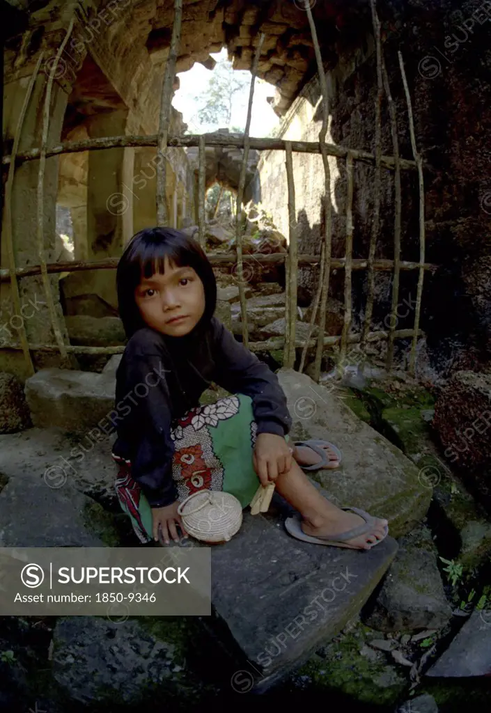 Cambodia, Seim Reap, Girl Sitting At Banteay Srei Or The Citadel Of The Women Where Children Act As Guides To Earn Money For Schooling