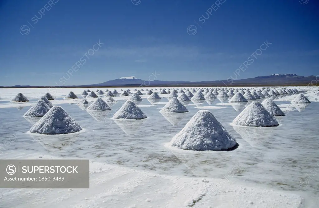 Bolivia, Uyuni, Salar De Uyuni, Salt Flats With Salt Shovelled In To Piles Awaiting Collection