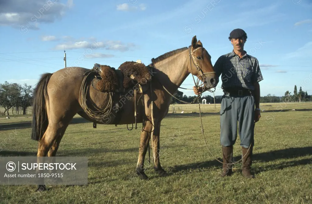 Uruguay, Farming, Gaucho Holding Horse.