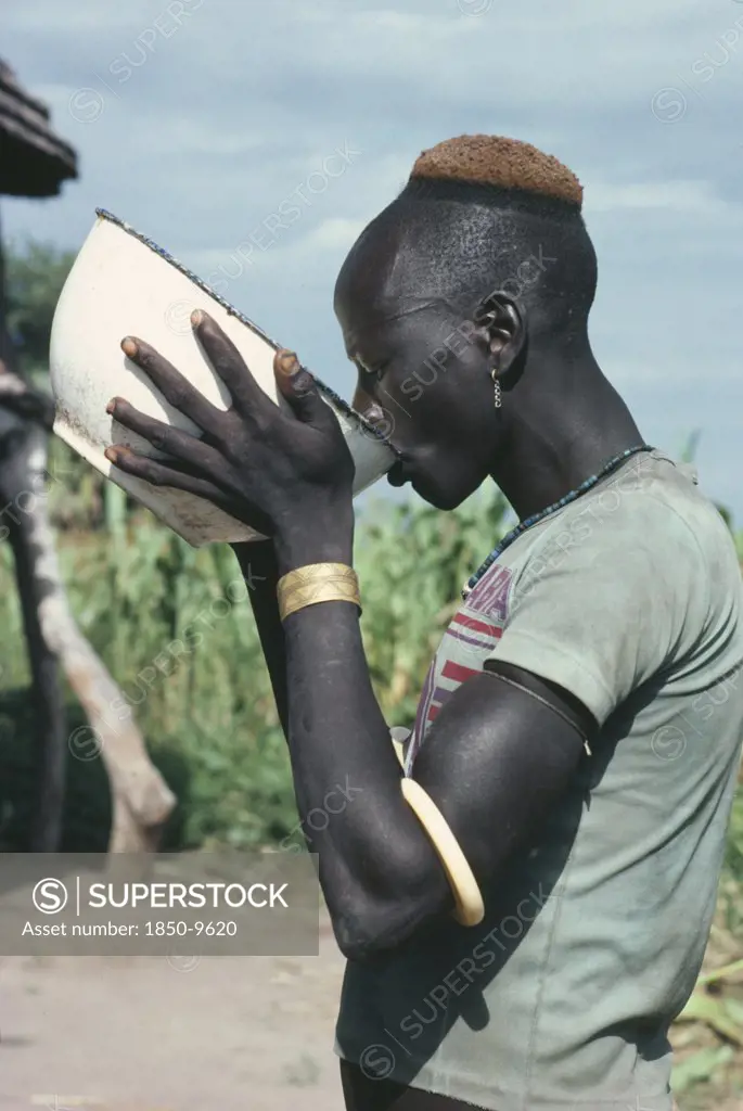 Sudan, Tribal Peoples, Dinka Man Drinking Groundnut Gruel At Ceremony Welcoming Young Men Back To Village After Spending Eight Weeks At Fattening Camp.