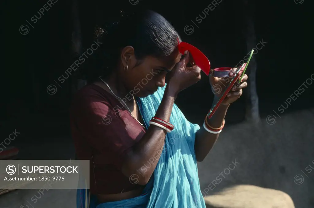 India, Religion, Hinduism, Young Woman Applying Red Sindoor Paste To Central Parting Of Hair To Signify That She Is A Married Hindu.