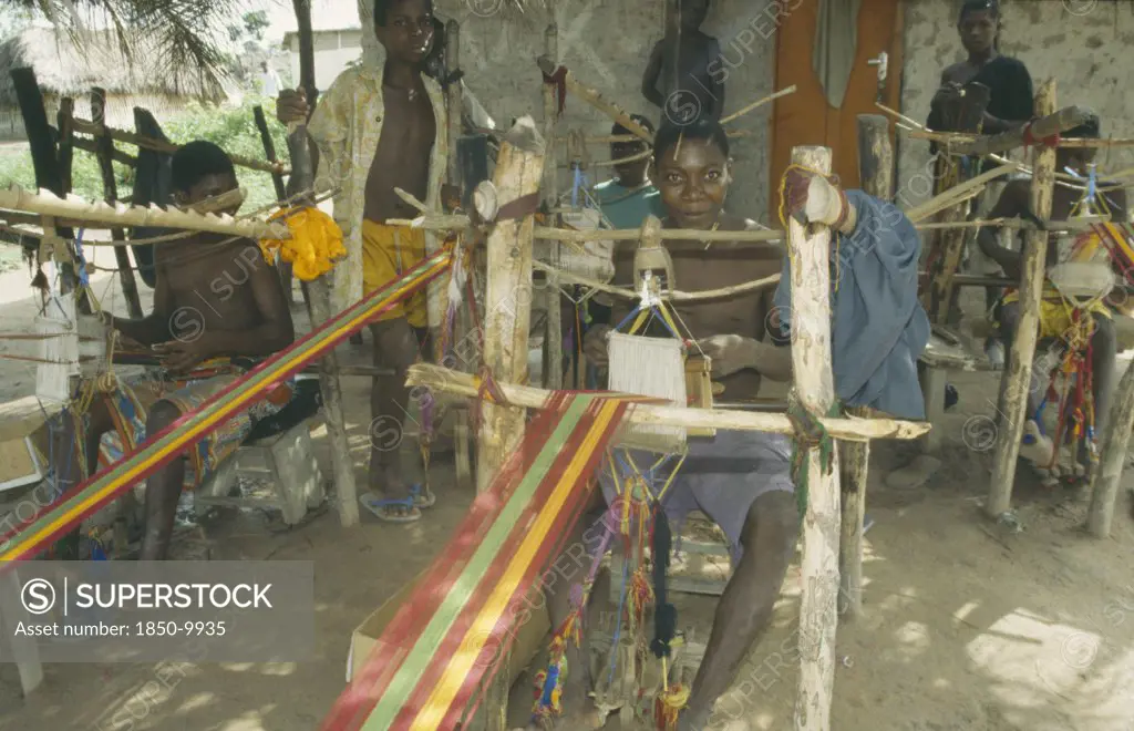 Ghana, Ashanti Region, Kumasi, Weaver At Hand Loom Prodcungin Traditional Multi Coloured Kente Cloth
