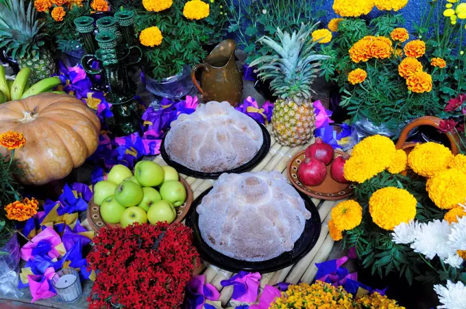 Mexico, Michoacan, Patzcuaro, Altar with display of food and flowers including marigolds for Dia de los Muertos or Day of the Dead festivities.