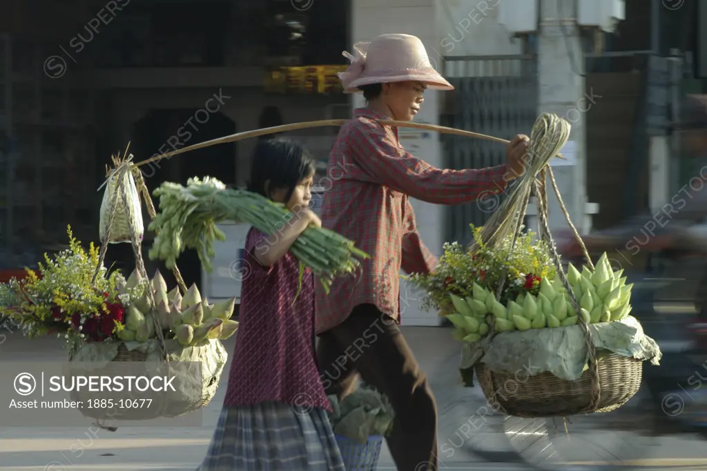 Cambodia, , Siem Reap , Mother and daughter carrying produce to market